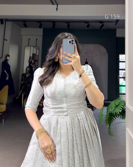 Woman taking a mirror selfie wearing a white dress in an indoor setting.
