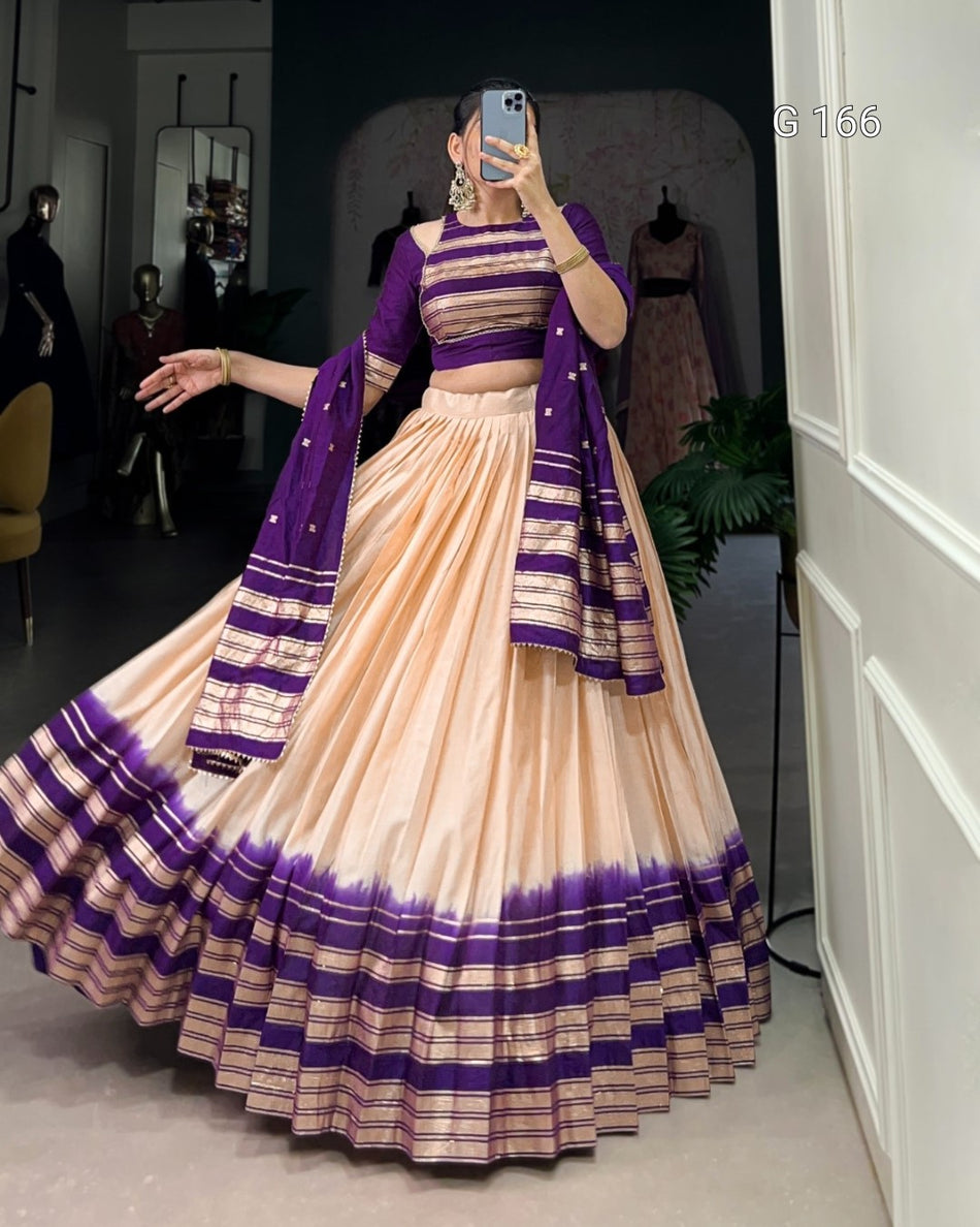 Woman in a traditional outfit with purple and beige patterns taking a mirror selfie.