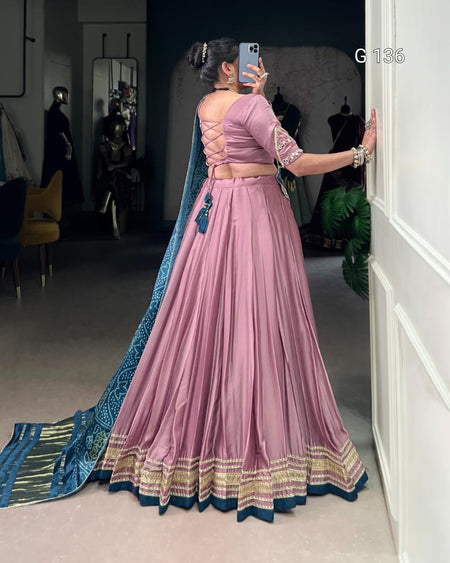 Person wearing a pink saree with blue border taking a mirror selfie.