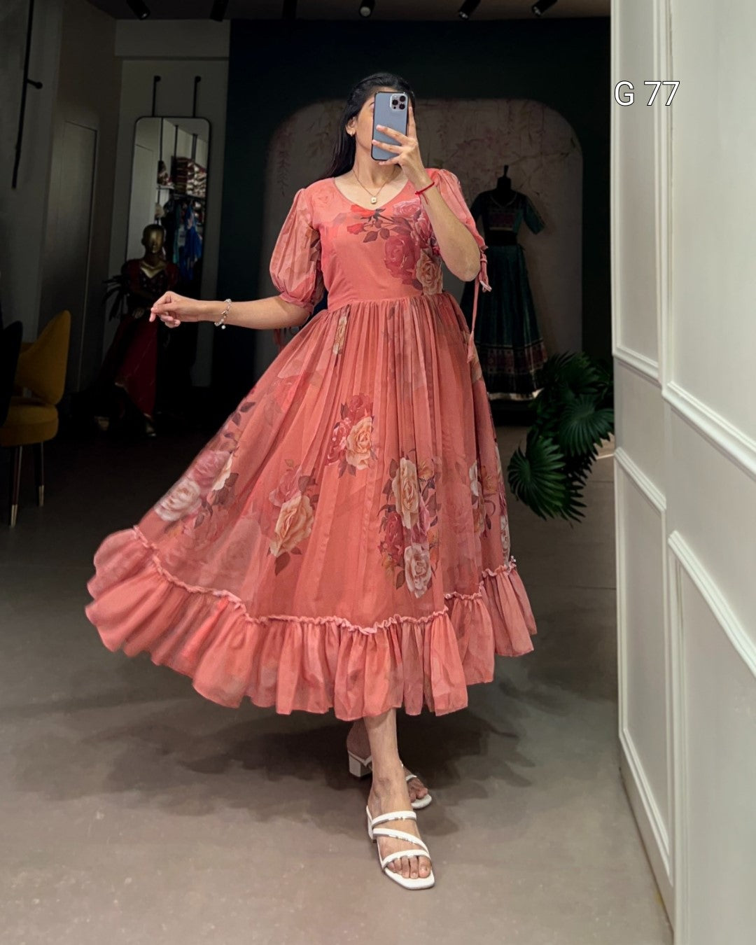 Person wearing a pink floral dress in an indoor setting
