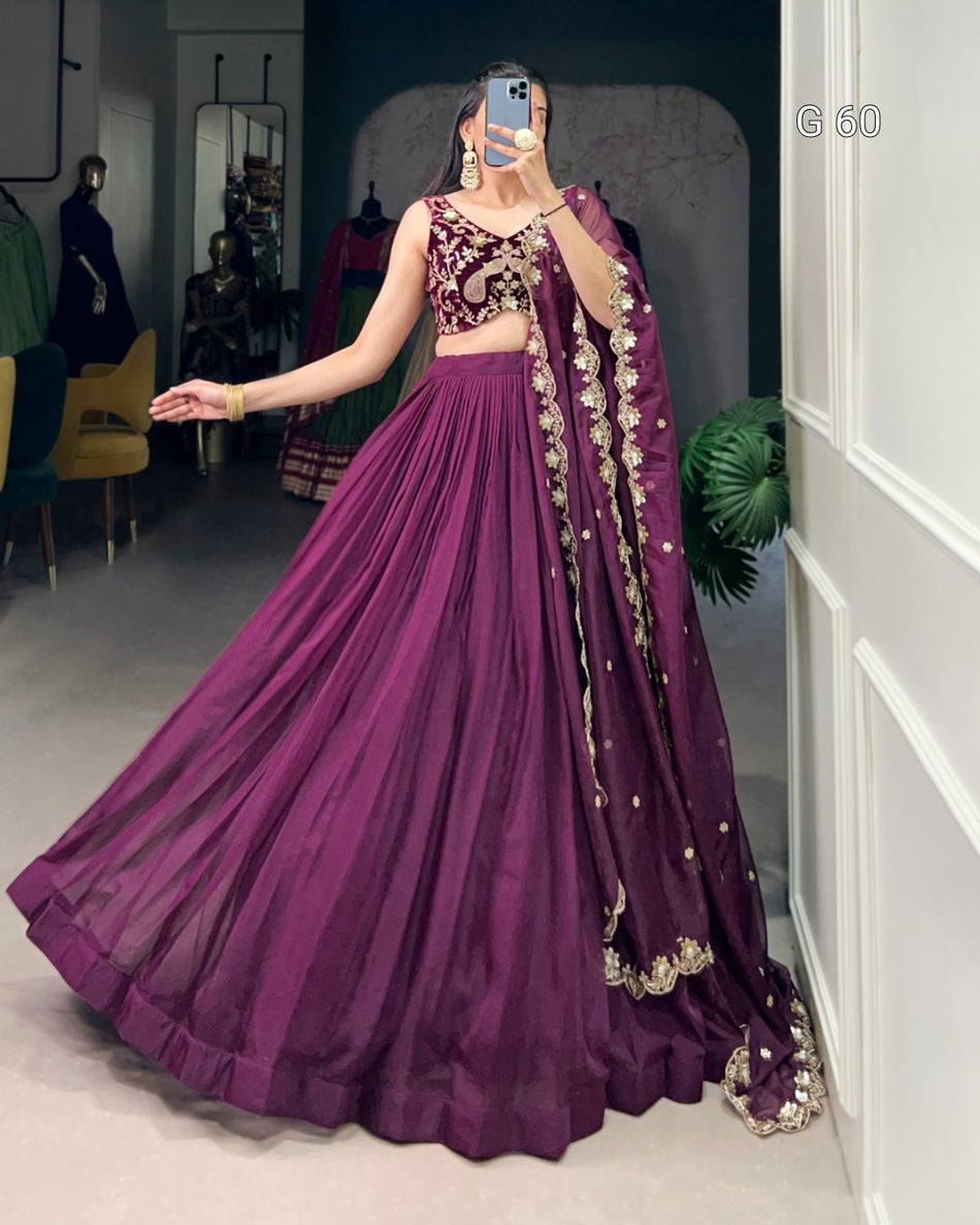 Woman in a purple traditional outfit with gold details in an indoor setting
