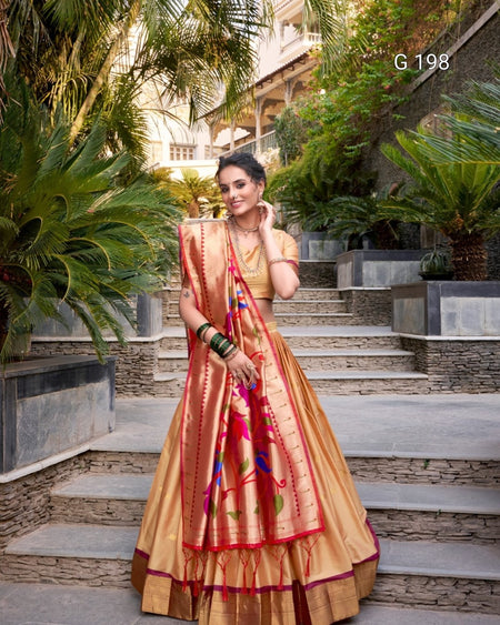 Woman in a traditional saree standing outdoors with plants and steps in the background