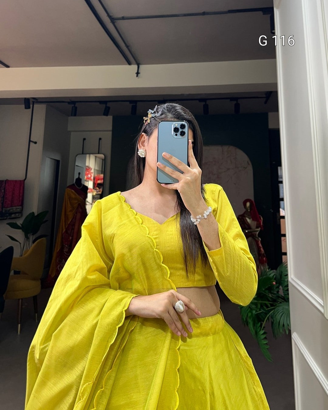 Person wearing a bright yellow outfit taking a mirror selfie.
