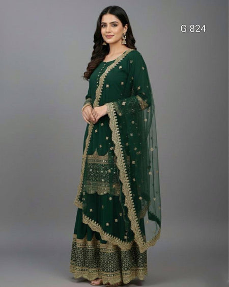 Woman wearing a green traditional outfit with gold embroidery on a gray background