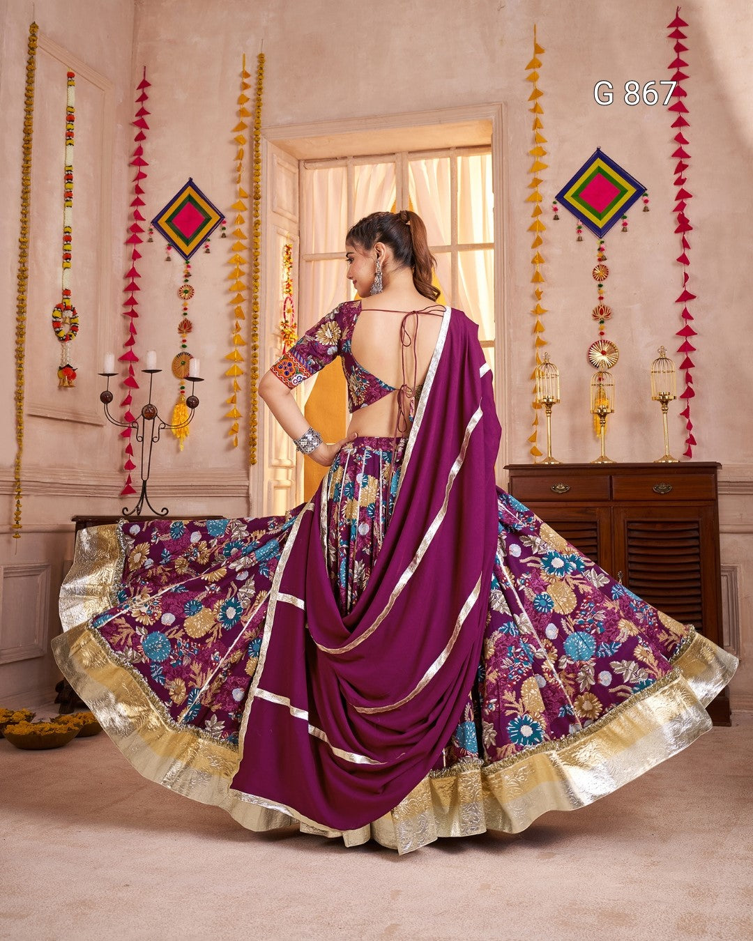 Woman in a colorful saree with a decorative interior background