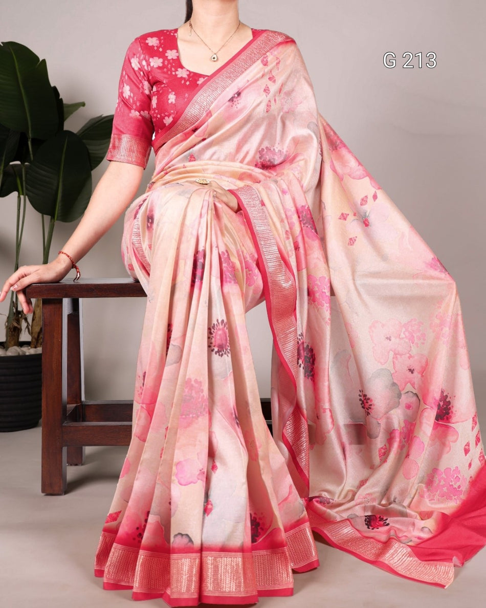 Woman wearing a pink and beige saree with floral patterns on a gray background