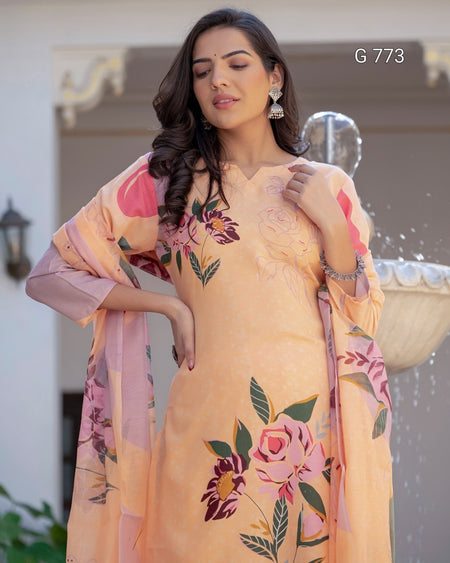 Woman wearing a peach floral dress with a matching shawl outdoors.