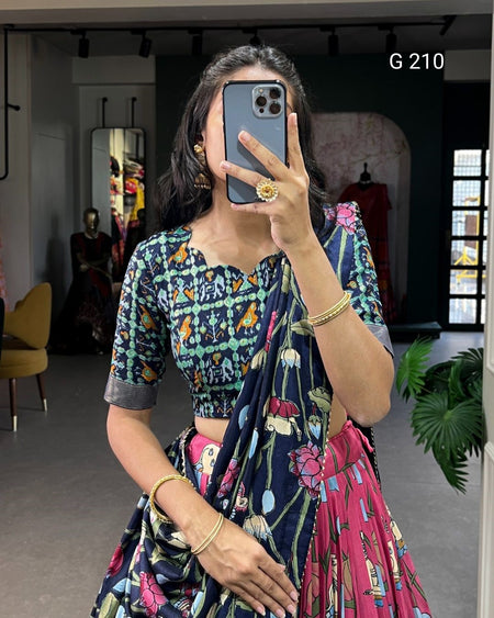 Woman taking a mirror selfie wearing a colorful traditional outfit with a patterned blouse and saree.