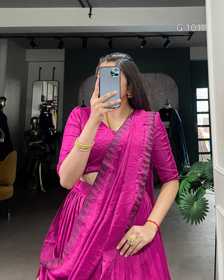Woman taking a mirror selfie wearing a bright pink saree with a dark border.
