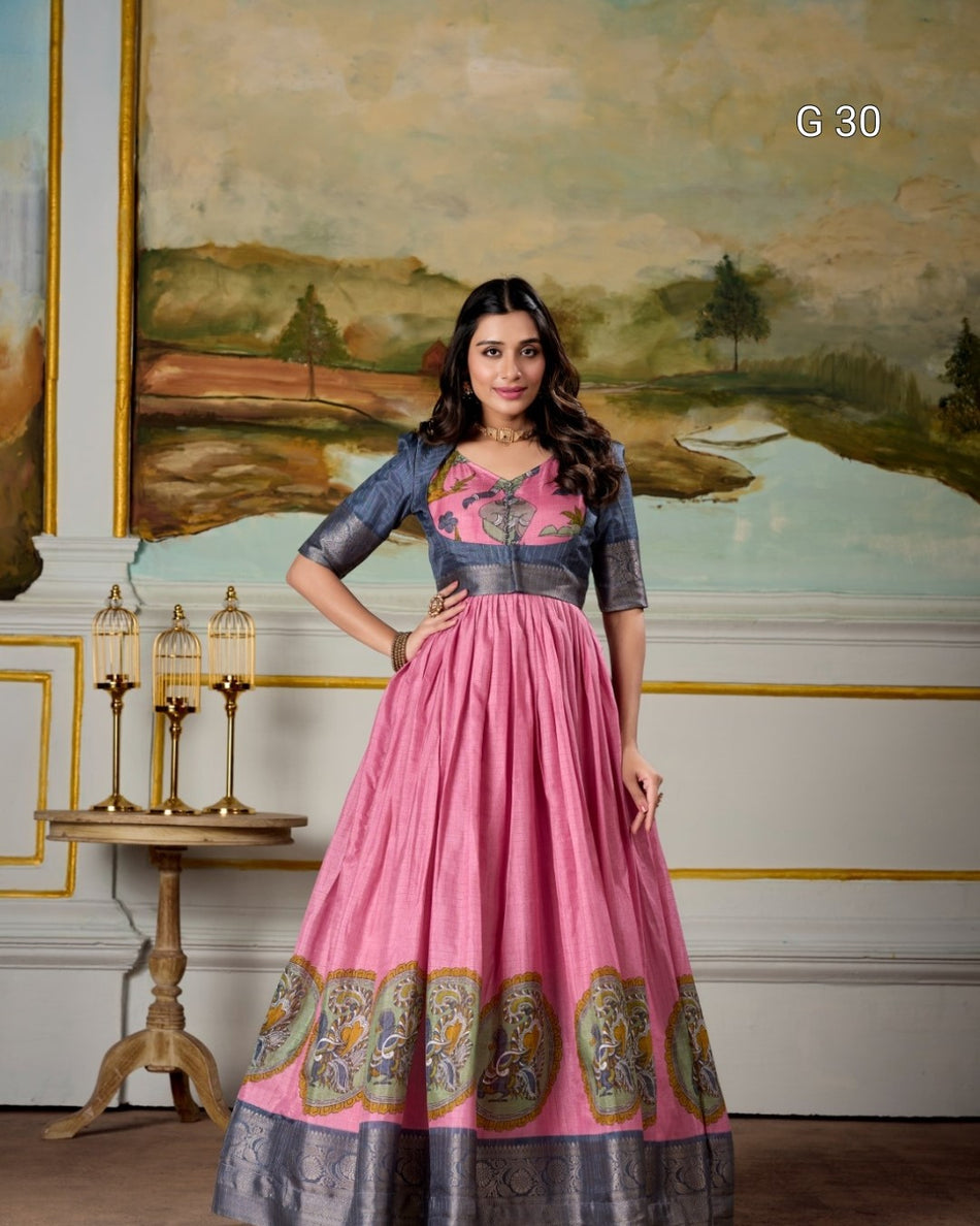 Woman in a pink and gray traditional outfit standing in a decorated room with a painting in the background.
