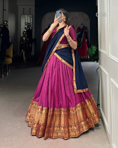 Person wearing a traditional outfit with a pink and blue saree in a room.