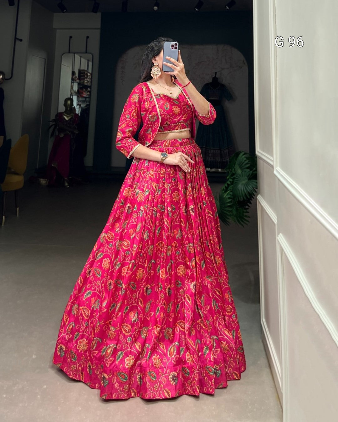 Person wearing a red floral outfit taking a mirror selfie.