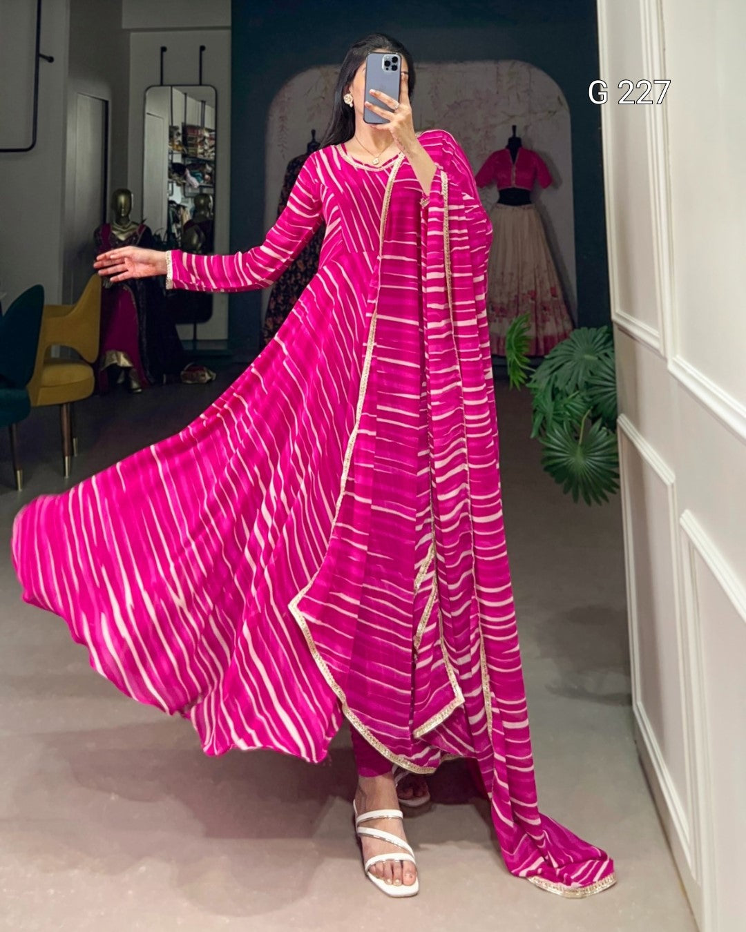 Woman wearing a long pink dress with white stripes in an indoor setting.