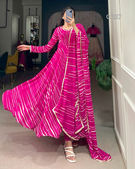 Woman wearing a long pink dress with white stripes in an indoor setting.