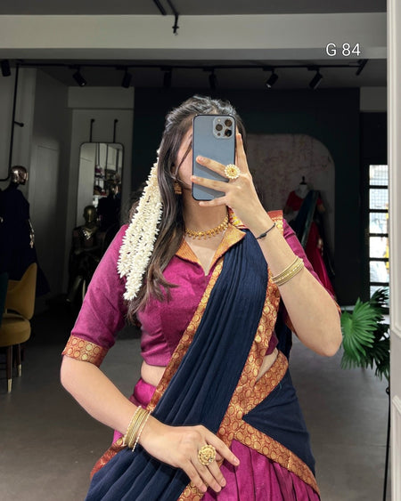 Woman taking a mirror selfie wearing a traditional saree in an indoor setting.
