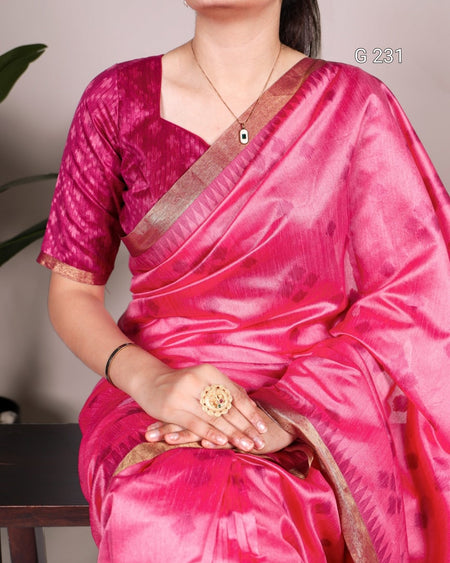 Person wearing a pink saree with a brown border, holding a decorative ring.
