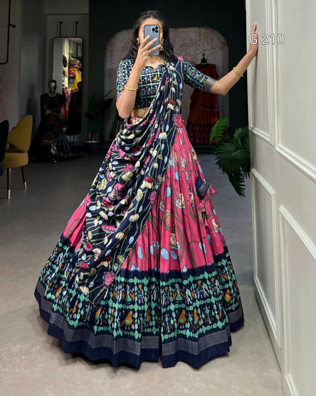 Person wearing a colorful traditional outfit with a patterned design, standing in a room.