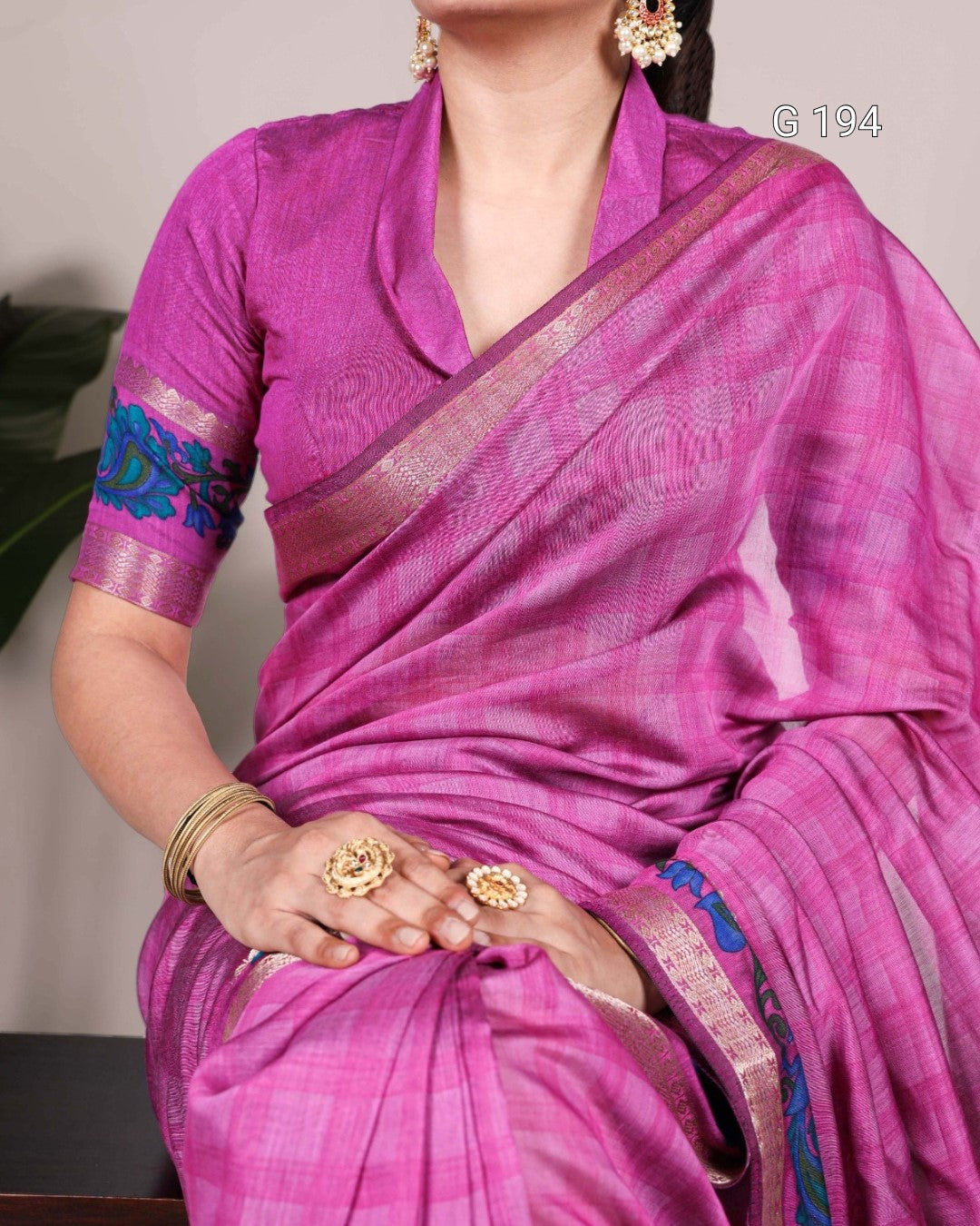 Woman wearing a pink saree with a plain background