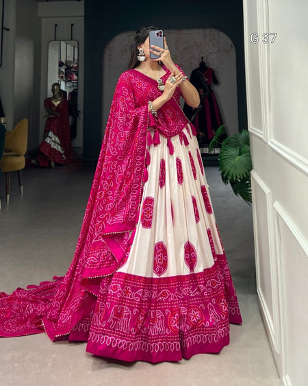 Woman wearing a pink and white traditional outfit with a matching dupatta in a room.