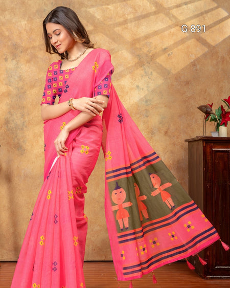 Woman wearing a pink saree with intricate designs against a warm-toned wall.