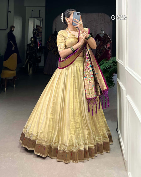 Woman in a light yellow traditional outfit with a colorful scarf in a fitting room.