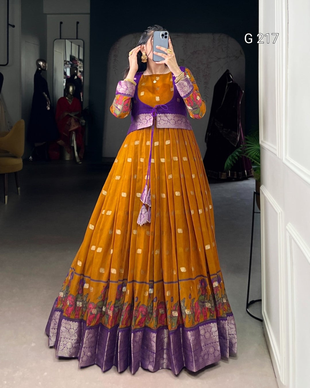 Traditional outfit with a purple blouse and orange skirt in a room setting.