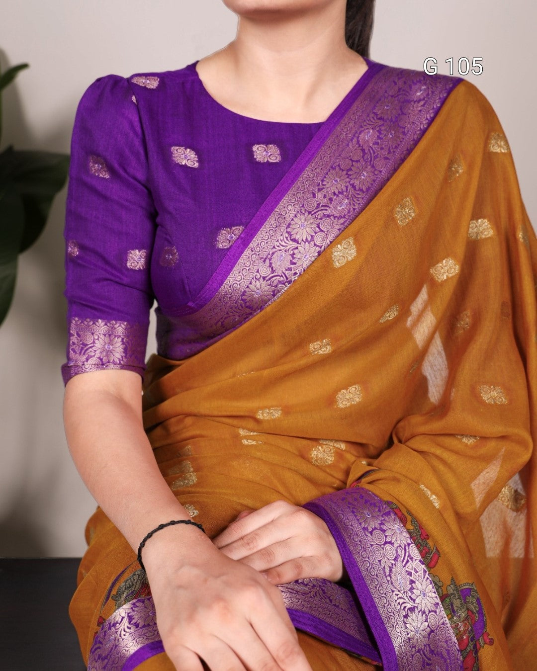 Person wearing a traditional saree with purple blouse and brown saree