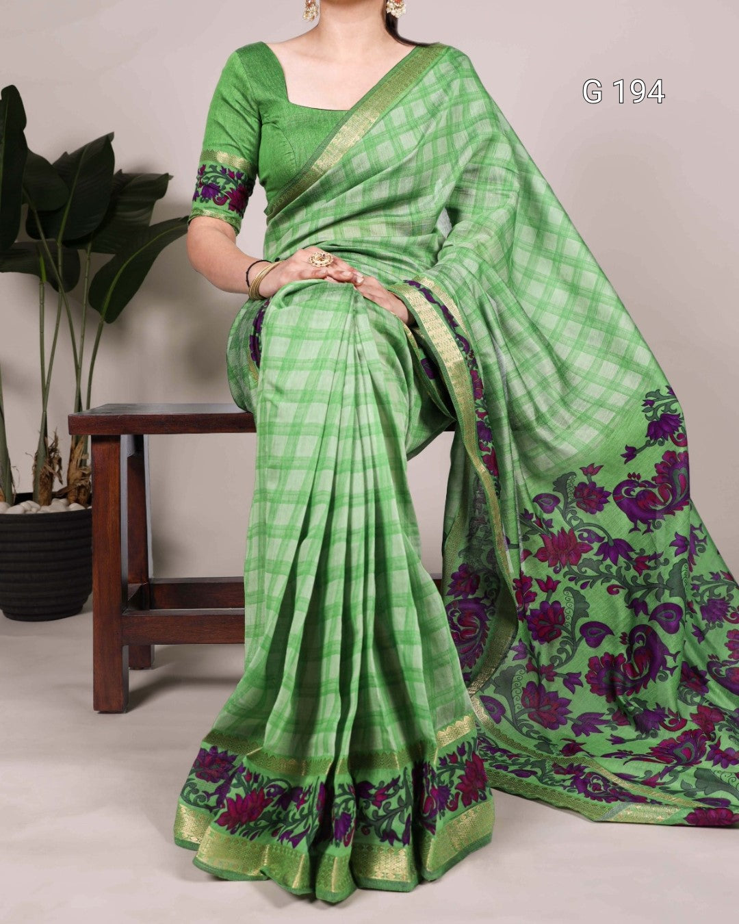 Green saree with floral patterns on a neutral background