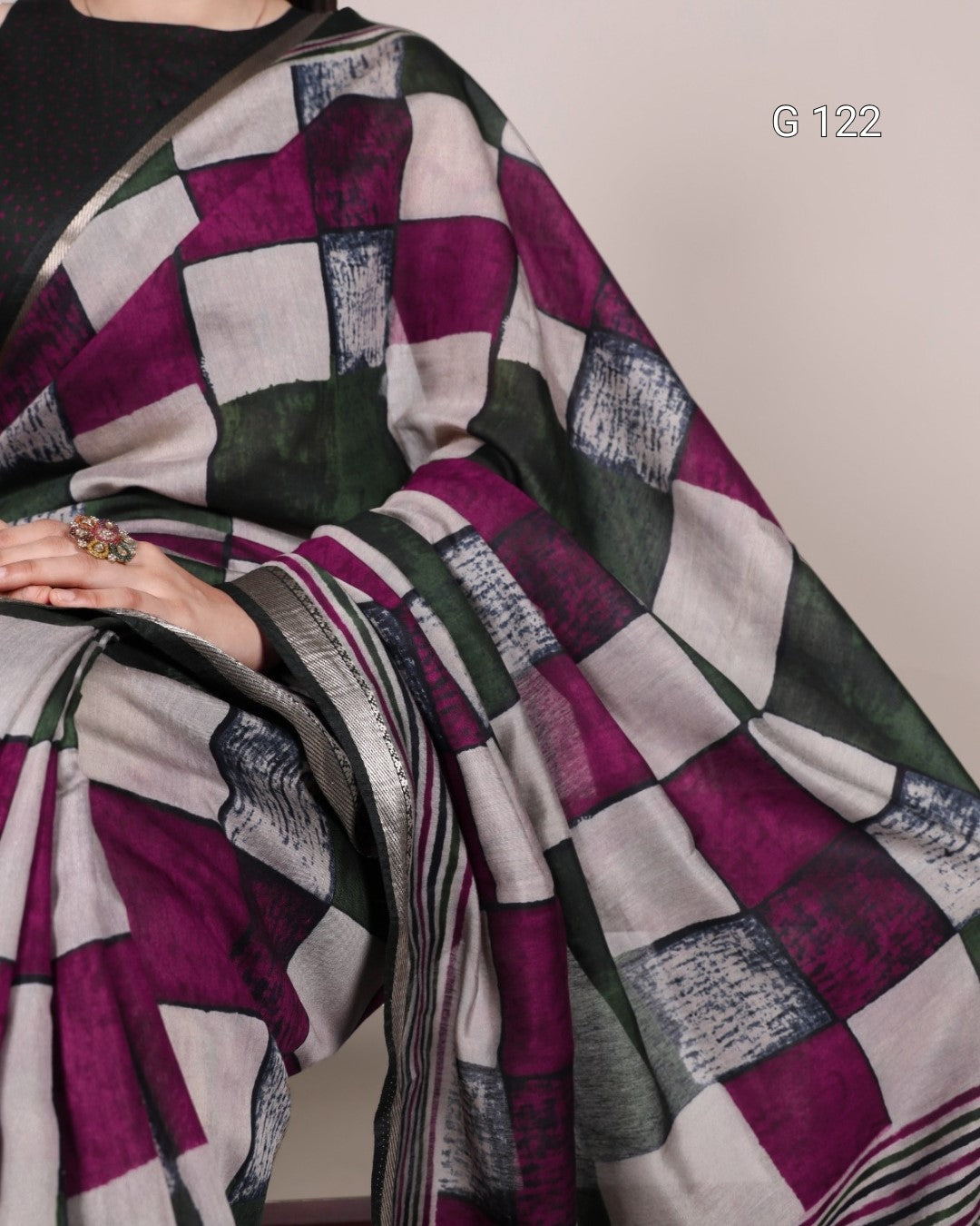 Saree with a geometric pattern draped over a person, on a plain background