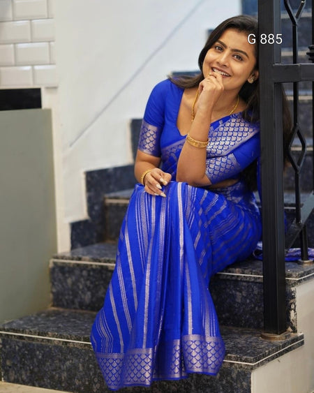 Woman in a blue saree sitting on steps indoors