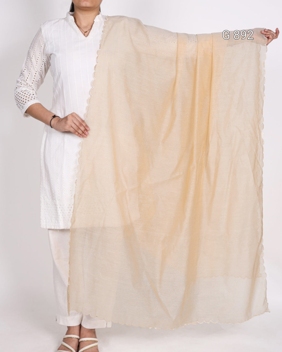 Person holding a beige scarf with a white background