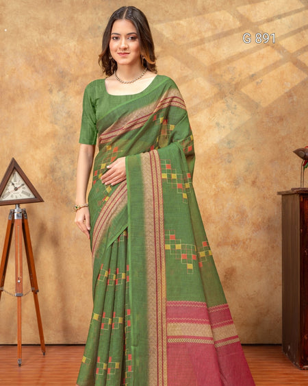 Woman wearing a green saree with a patterned border against a brown background