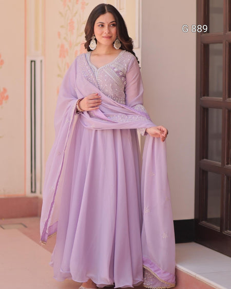 Woman wearing a lavender traditional outfit with a matching dupatta indoors.