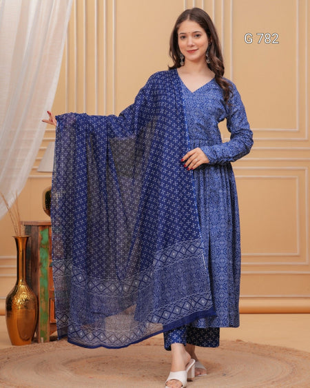 Woman wearing a blue patterned outfit with a matching dupatta in an indoor setting.