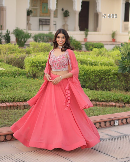 Woman in a pink traditional outfit standing in a garden setting