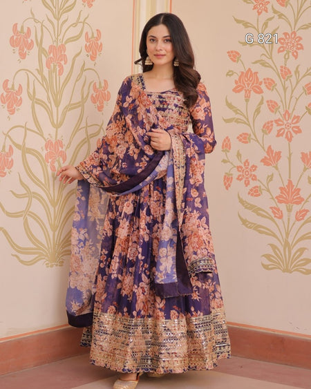 Woman wearing a floral dress with a matching shawl in a room with decorative walls.