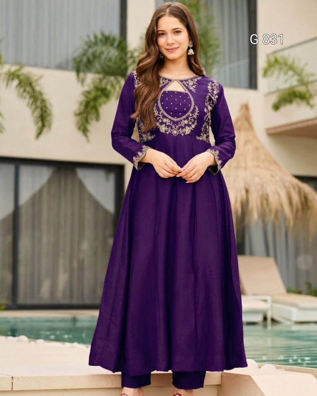 Woman wearing a purple dress with intricate embroidery by a poolside.