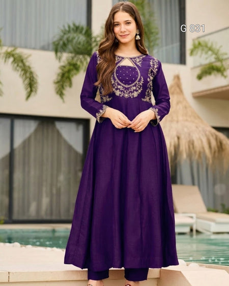 Woman wearing a purple dress with intricate embroidery by a poolside.