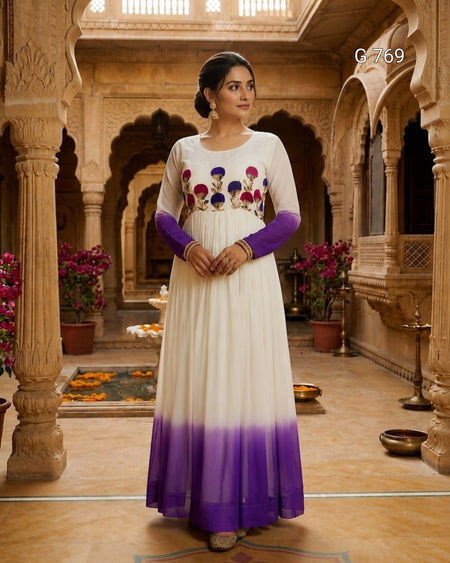 Woman in a white and purple traditional outfit standing in an ornate indoor setting.