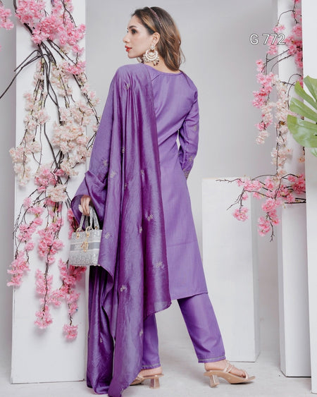 Woman wearing a purple outfit with floral decorations on a white background