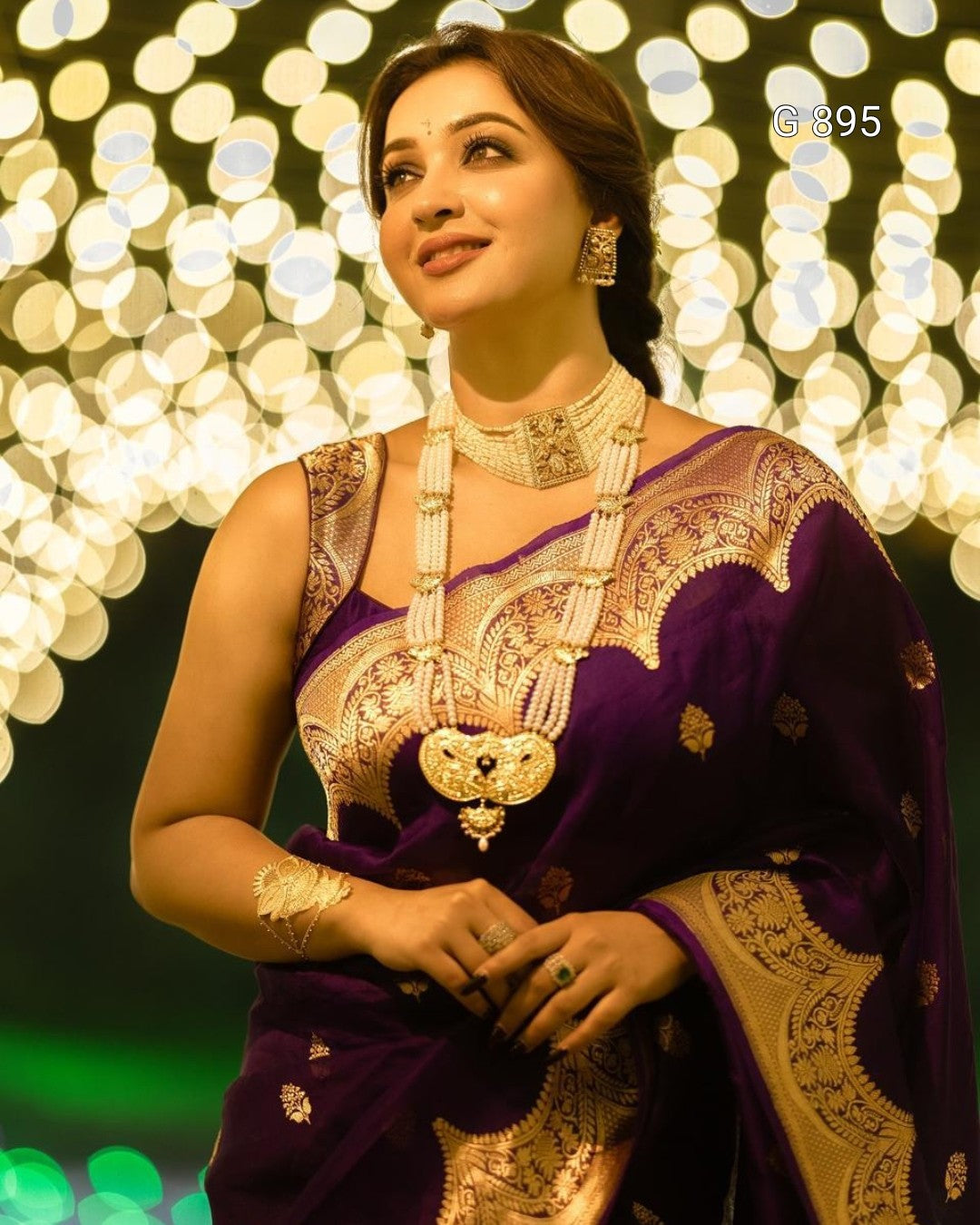 Woman in traditional attire with jewelry against a bokeh light background