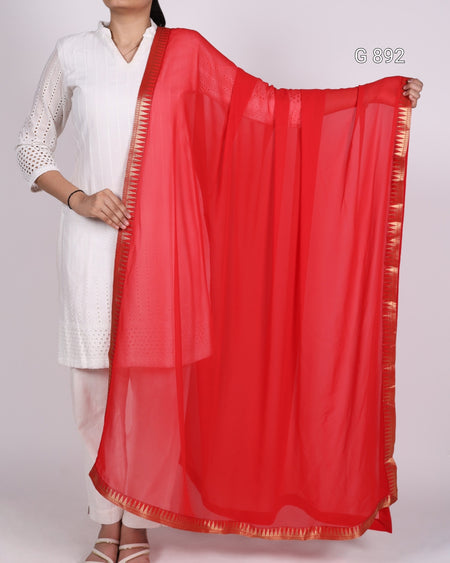 Red saree with a white blouse and red border held by a person on a white background