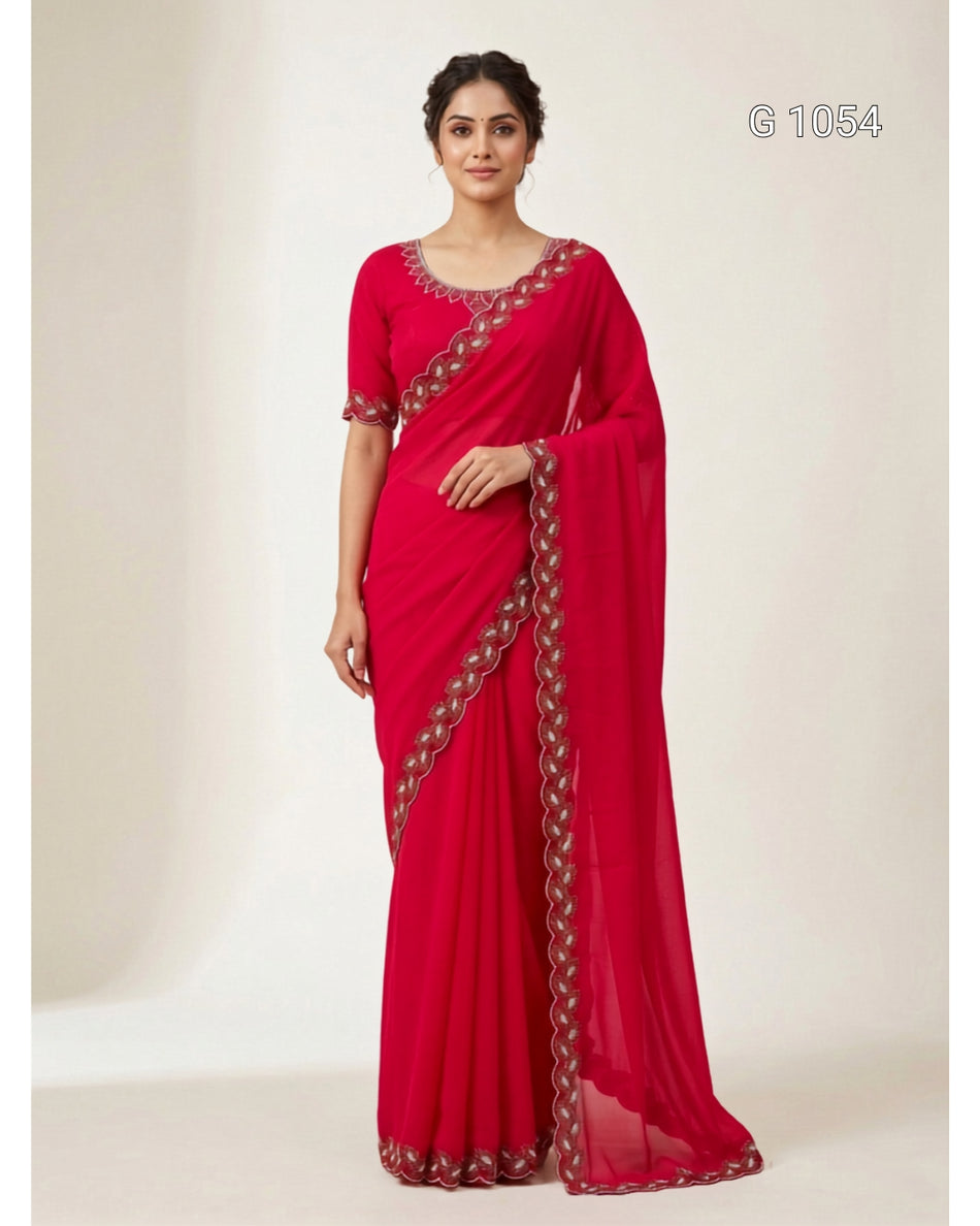 A woman modeling a bright red georgette saree with a matching blouse, featuring a decorative metallic border along the drape and sleeve. The image is shot against a plain, light beige studio background with a code 'G 1054' in the top right corner.