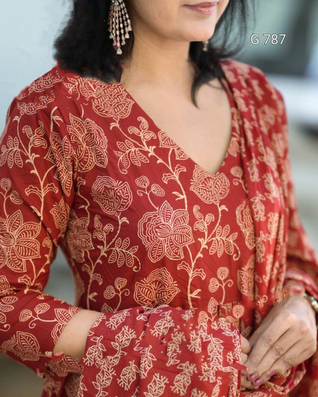 Woman wearing a red floral patterned outfit with a blurred background