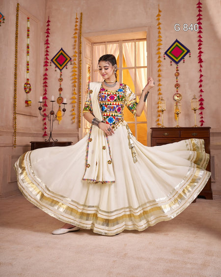 Woman in a traditional outfit with colorful patterns in a decorated room.