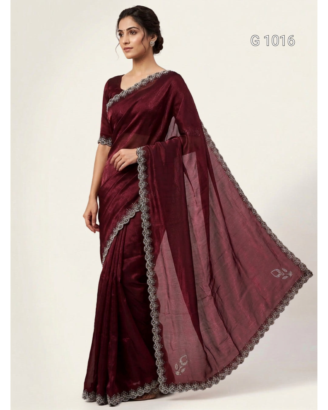 A woman modeling a deep maroon/burgundy saree with a matching blouse and a sheer dupatta featuring gray floral lace borders. The text 'G 1016' is visible in the top right corner against a plain light beige background.