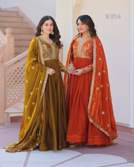 Two women in traditional embroidered dresses standing indoors.