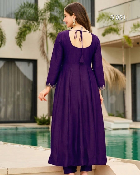 Woman wearing a purple dress with a backless design by a poolside.