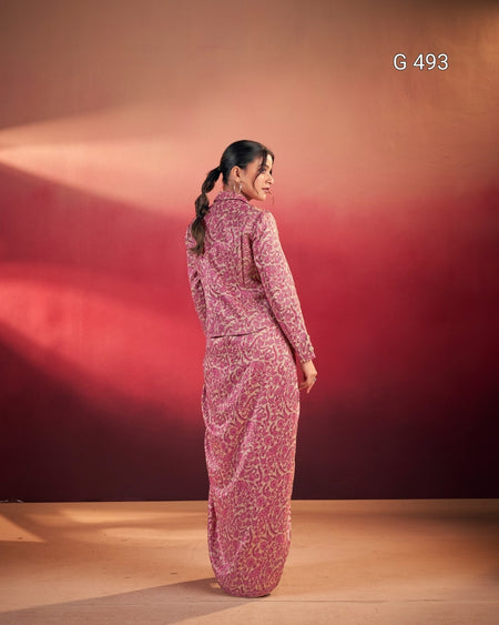 Woman in a pink floral dress standing against a gradient wall with 'G 493' text.