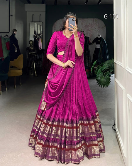 Woman wearing a vibrant pink saree with a dark background
